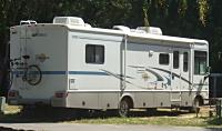 A large RV with an awning and a bike rack