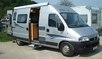 A small campervan with awning and bikerack